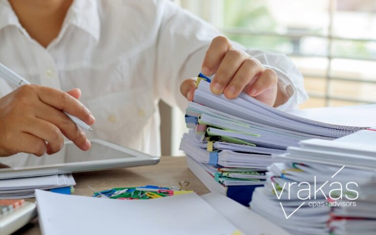 Person sorting through paperwork on their desk