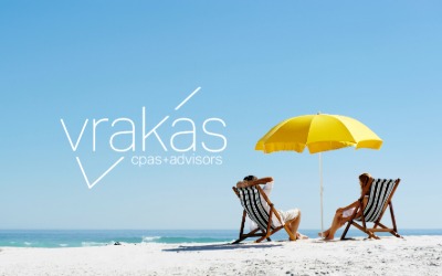 People sitting on beach chairs under an umbrella overlooking the ocean.