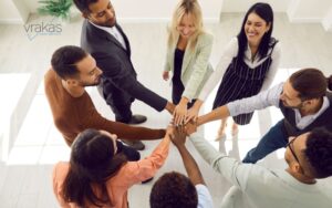 Group of people putting their hands in to celebrate