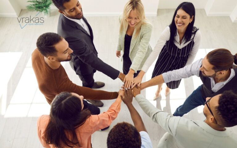 Group of people putting their hands in to celebrate
