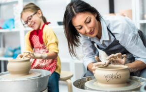 A woman creating clay pottery on a wheel.
