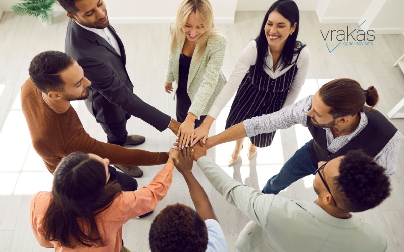 Group of people putting their hands in to celebrate