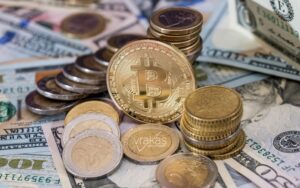 Stacked gold coins with a Bitcoin logo and American money.