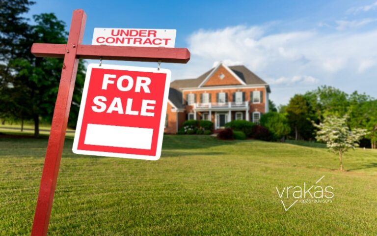 For Sale sign in front of home and a field.